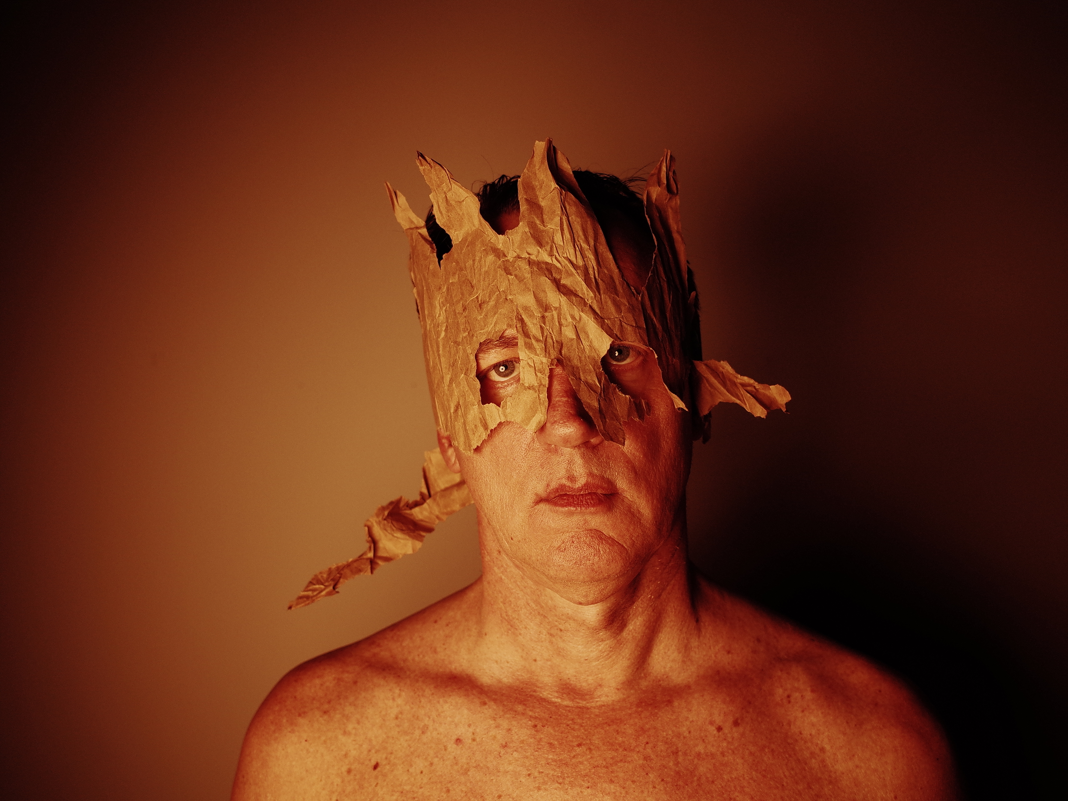 Portrait of Christopher Ryan with a torn paper mask, by Parker Pfister