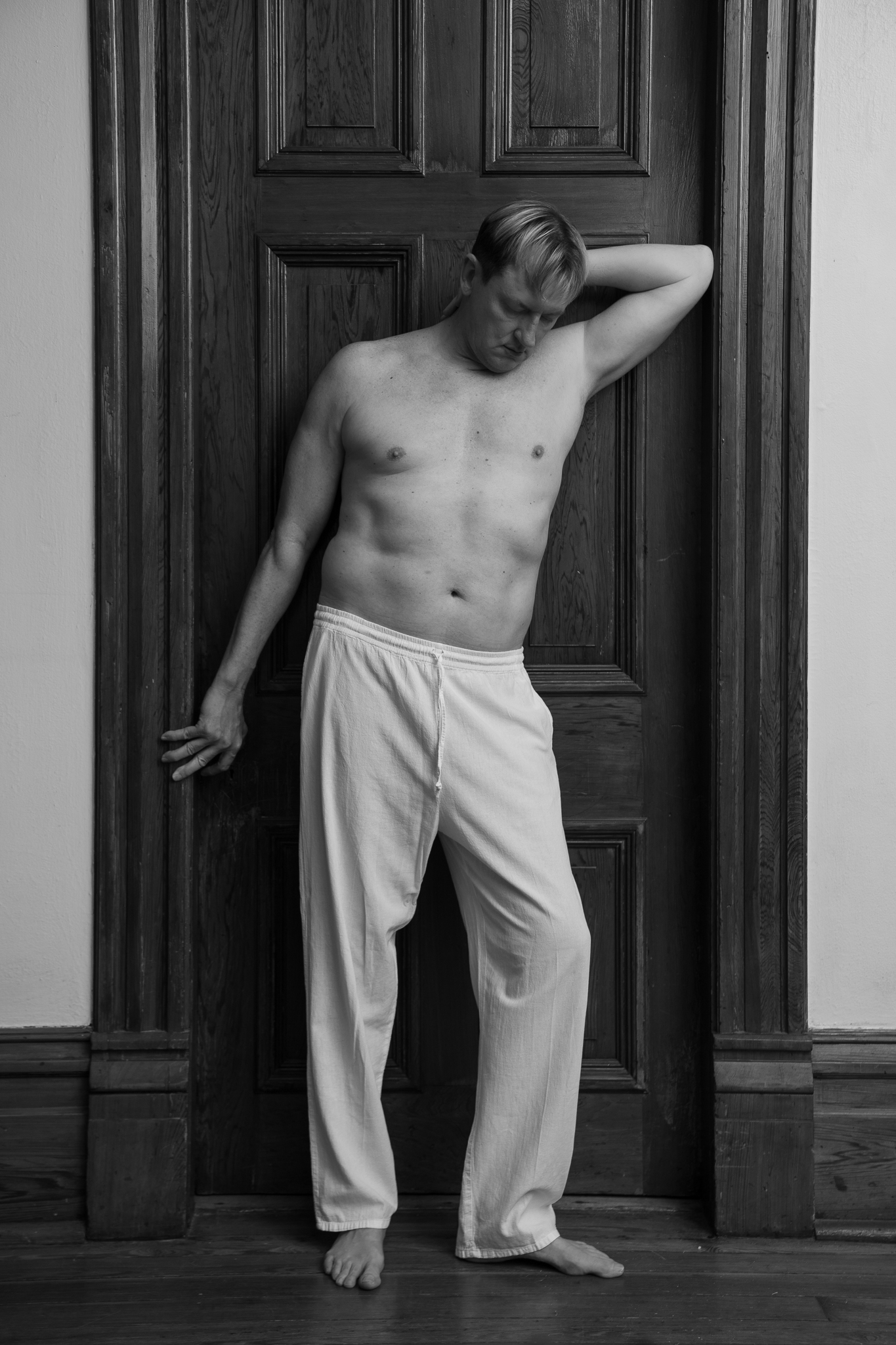 Black and white portrait in a wood-paneled doorway